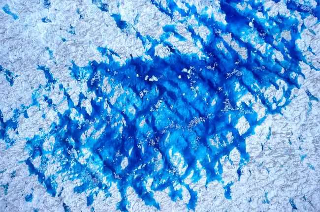 Patrón abstracto texturizado azul y blanco que recuerda al hielo o al agua, tomado con un dron. Imagen de dron de Sermeq Kujalleq en Kangia. Crédito: Andrea Kneib-Walter y Guillaume Jouvet