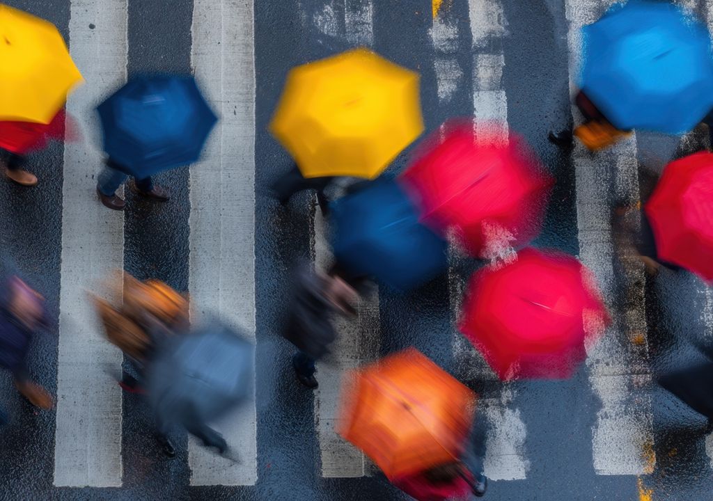 personas cruzando una calle mojada, usando paraguas