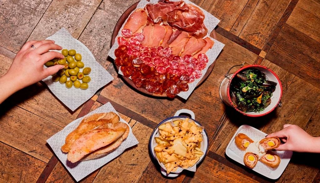 tapas Embutidos fríos, pintxos, tortillas y croquetas son parte de la experiencia de compartir en De La Ostia. Imagen: @delaostia_cl