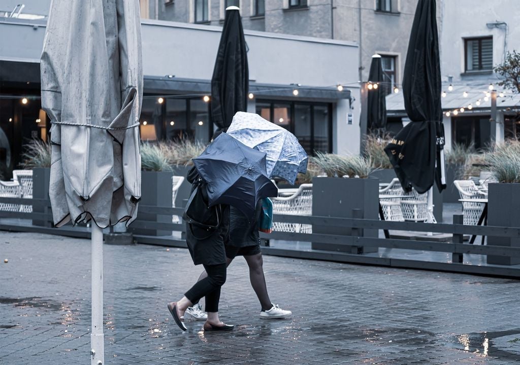 personas protegiéndose con un paraguas de la lluvia y el viento personas protegiéndose con un paraguas de la lluvia y el viento
