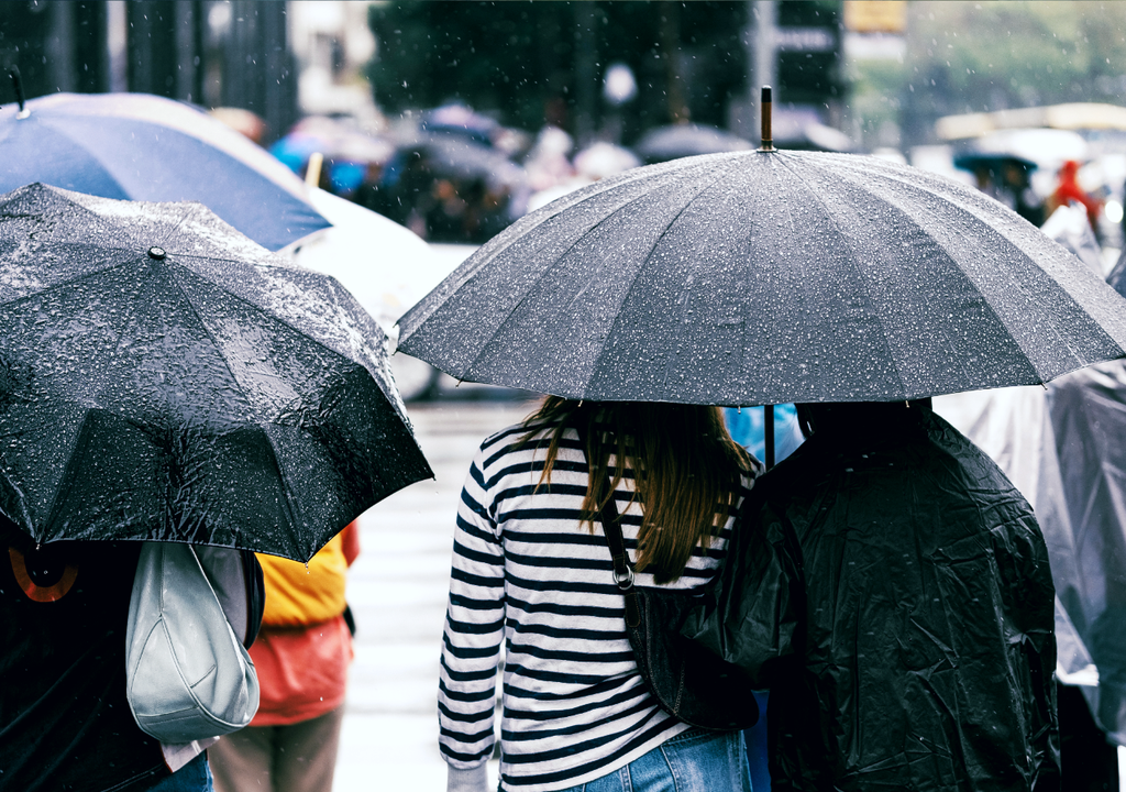 personas en la calle, protegiéndose de la lluvia con paraguas Esta semana, el paraguas deberá quedarse a mano en algunas regiones de Chile.
