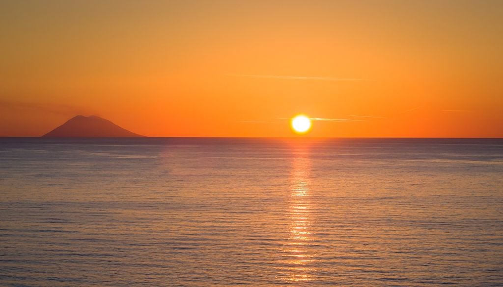 Dalla Calabria occidentale si può ammirare il tramonto dietro le Isole Eolie. Nella foto, il vulcano di Stromboli.