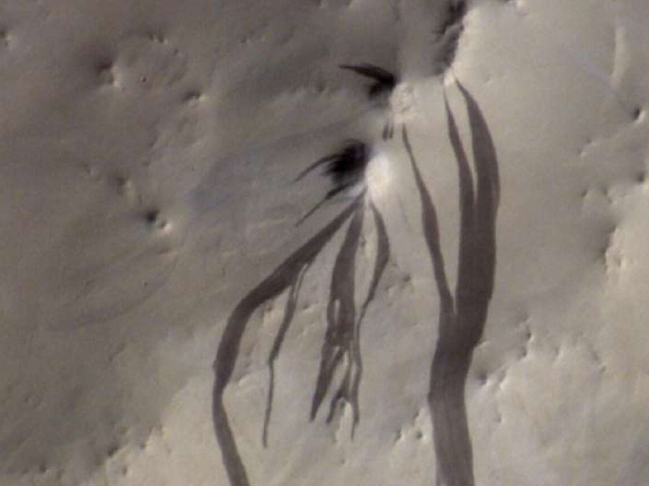 Franjas oscuras en forma de dedos que se extienden por la polvorienta superficie de Marte en Arabia Terra. Crédito: ESA