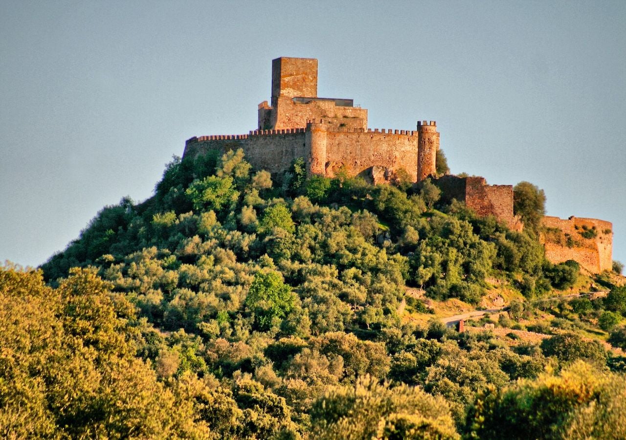 Elevado sobre la colina de Miraflores, este castillo domina visualmente el valle del río Guadiana, una ubicación estratégica que permitía controlar antiguas rutas comerciales y pasos fronterizos entre Castilla y Portugal.