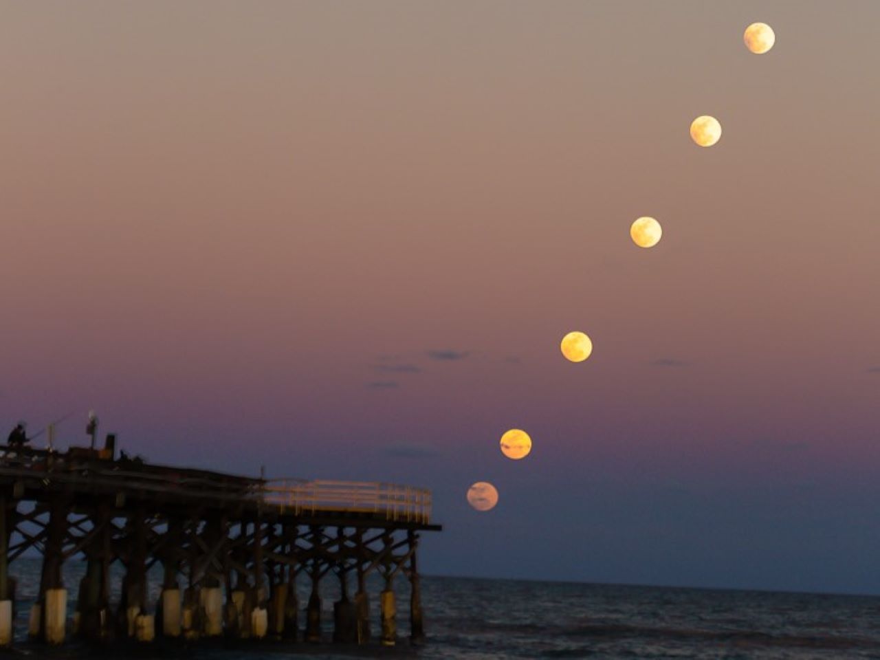Vista desde Cocoa Beach Pier, Florida. La Luna salió al atardecer el 10 de febrero de 2017, mientras se deslizaba a través de la tenue sombra exterior de la Tierra. Crédito & Copyright: Bill Jelen / NASA APOD