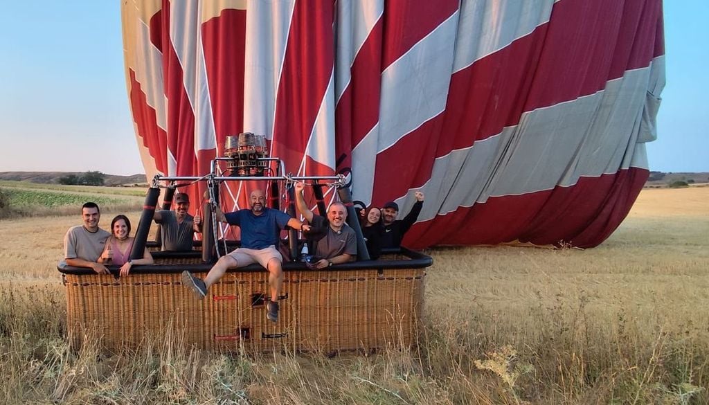 Photo de groupe des sept personnes ayant voyagé à bord de la montgolfière Muga, peu après l’atterrissage, près de la commune de Población de Arroyo, dans la province de Palencia. Photo : Globos Arcoíris. Photo de groupe des sept personnes ayant voyagé à bord de la montgolfière Muga, peu après l’atterrissage, près de la commune de Población de Arroyo, dans la province de Palencia. Photo : Globos Arcoíris.