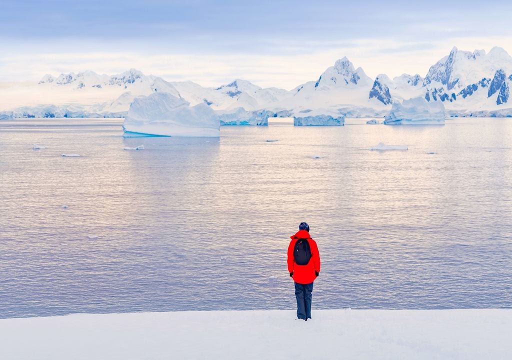 Antártica, persona con chaqueta roja, hielo derretido