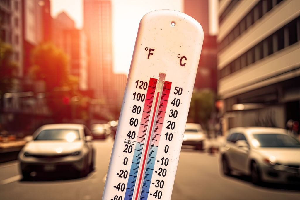 termómetro en primer plano frente a un fondo de ciudad en un día de altas temperaturas