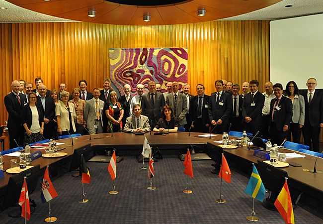 El Nuevo Centro De Datos Del Ecmwf Se Ubicará En Bolonia, Italia, Para 2019 El Jefe del Servicio Meteorológico Nacional de Italia, el Coronel Silvio Cau, y la Directora General del ECMWF Florence Rabier (sentados) firmaron el acuerdo de alto nivel sobre el centro de datos, en presencia de representantes de los 22 Estados miembros del ECMWF.