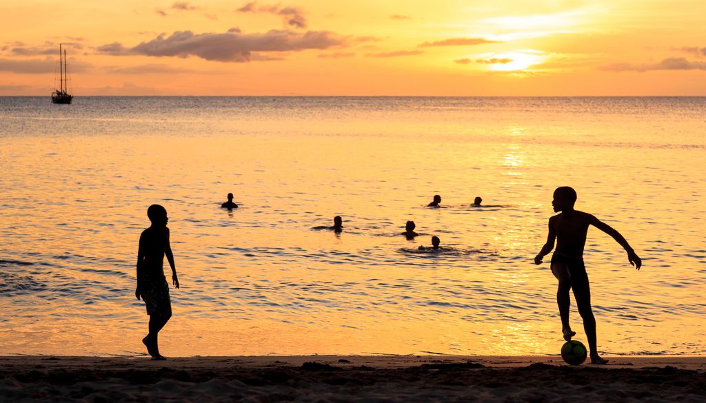 Niños jugando al fútbol al atardecer en la playa de Tarrafal, en la isla de Santiago, Cabo Verde.