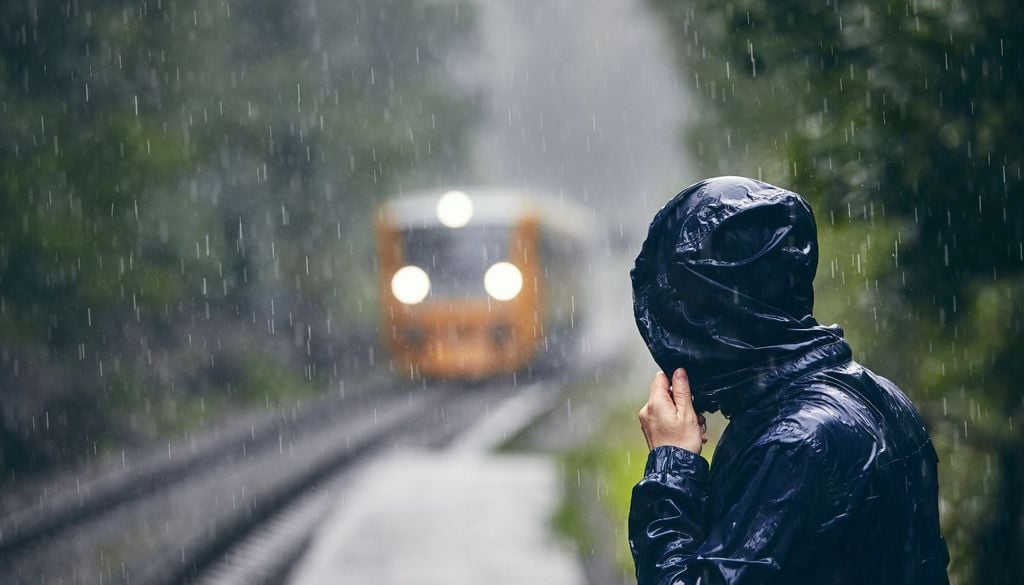 Persona esperando el tren en medio del temporal Las precipitaciones han provocado inundaciones de viviendas y bajos, vehículos atrapados, cortes de carreteras y problemas en el transporte ferroviario