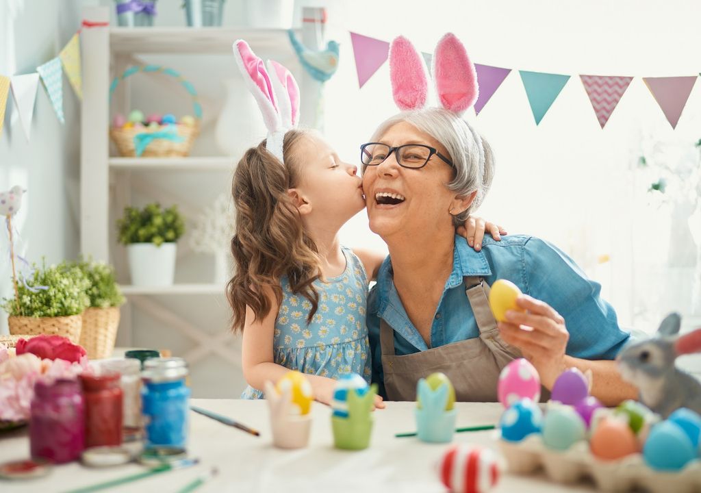 Abuelita con su nieta pintando huevos de Pascua
