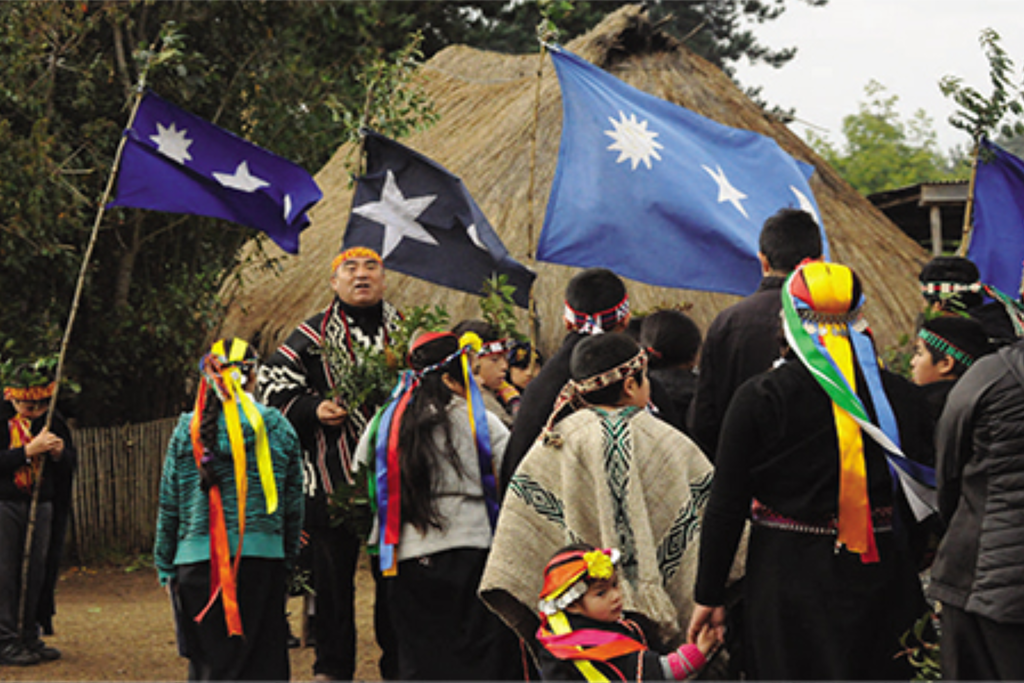 Una ceremonia mapuche frente a una ruka, Una ceremonia mapuche frente a una ruka, donde los símbolos del cielo, la naturaleza y la comunidad reflejan la estrecha relación entre la cosmovisión mapuche y los ciclos del territorio. SCIELO.