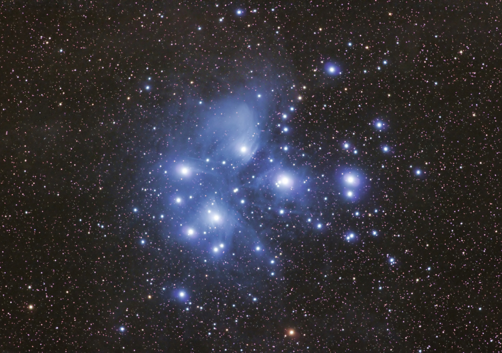 Las Pléyades brillan envueltas en un tenue velo azul.