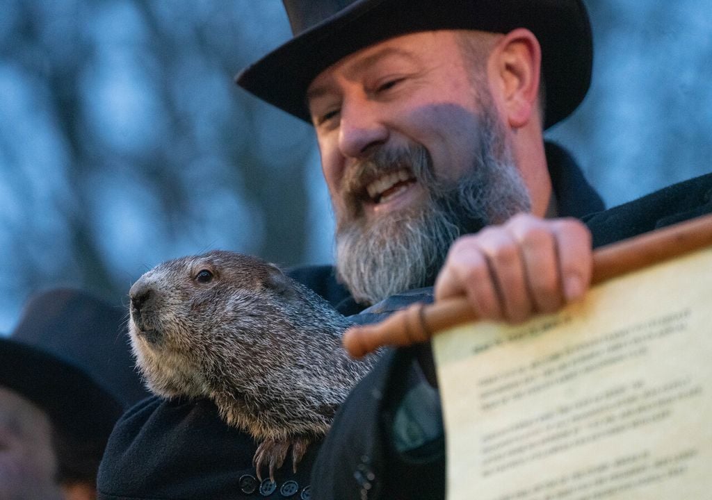 Annonce de la prévision de la marmotte Phil, dans les bras des membres du club de la marmotte de Punxsutawney. Source : Archives photographiques de GPA.