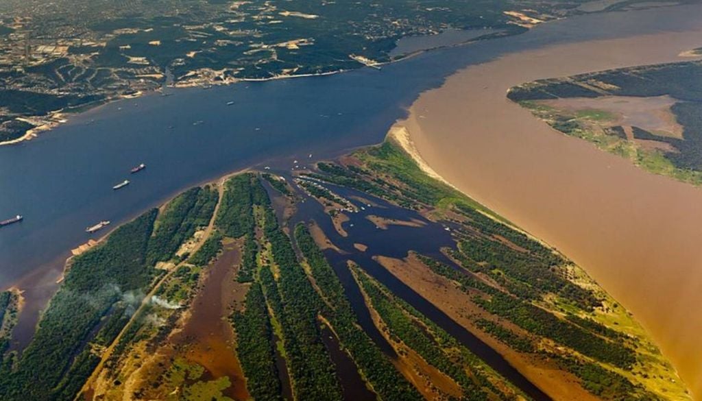 O ‘Encontro das Águas’, fenômeno que acontece entre dois rios diferentes em Alter do Chão, no Pará. Imagem aérea da região da Ponta Negra, que divide os rios. Crédito: Portal da Copa/Wikimedia Commons.
