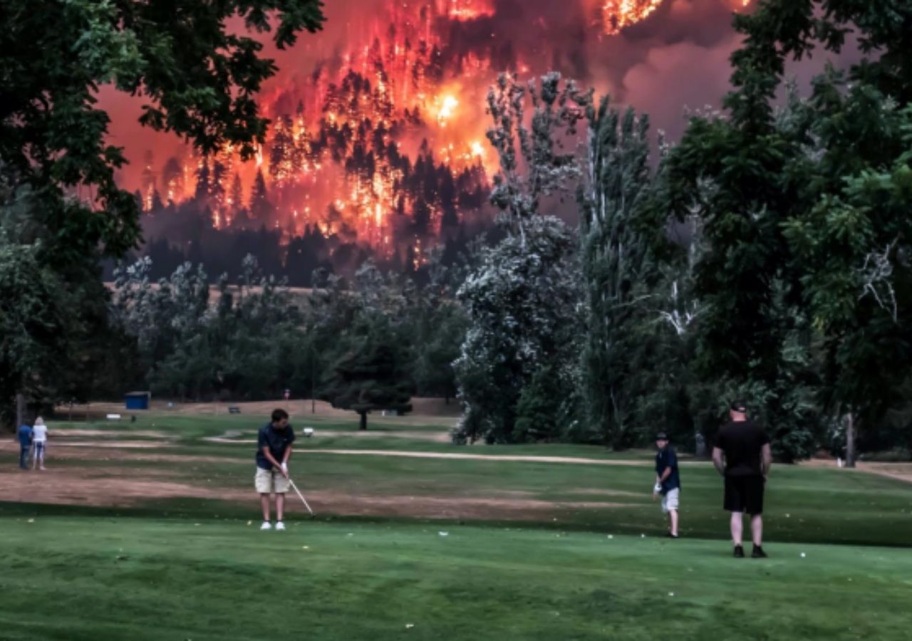 Jogadores de golfe terminam uma partida enquanto deflagra um incêndio florestal em Eagle Creek, perto de Portland, Oregon. Crédito: Kristi McCluer