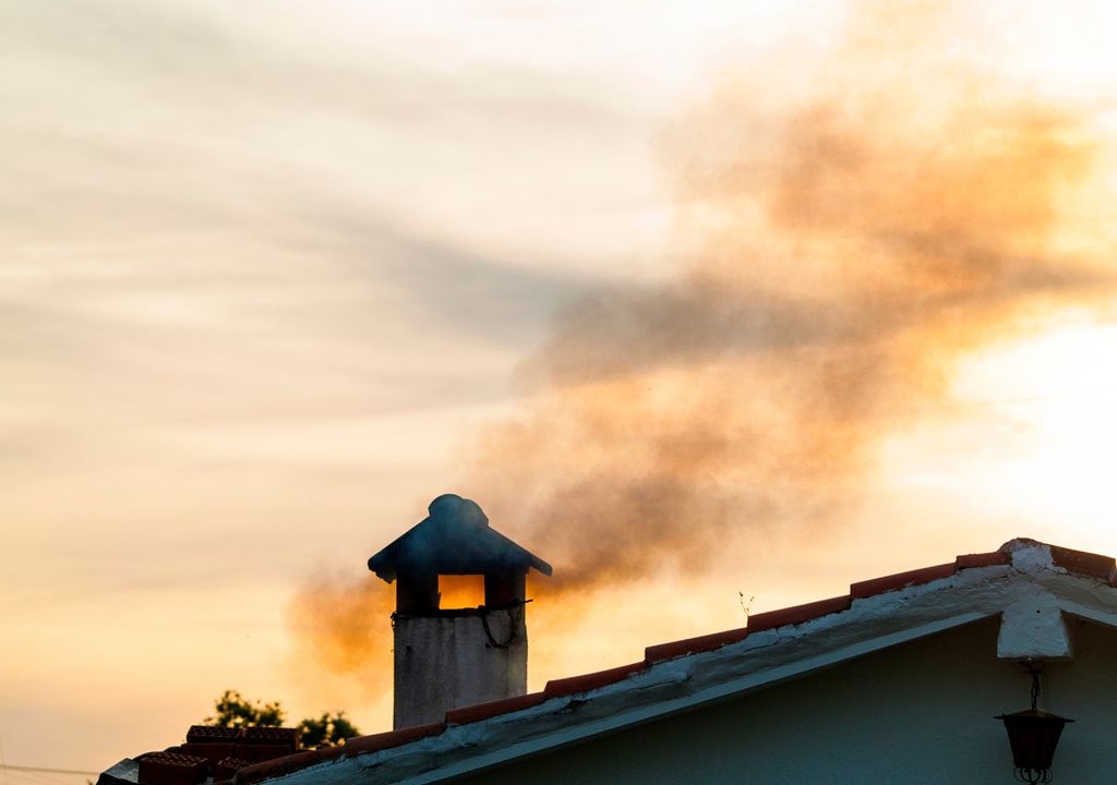 chimenea residencial emitiendo humo visible