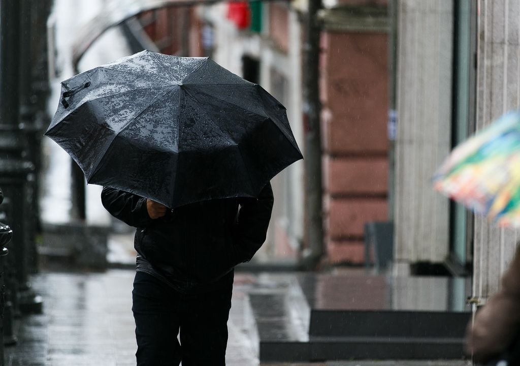 persona cubriéndose del viento y lluvia