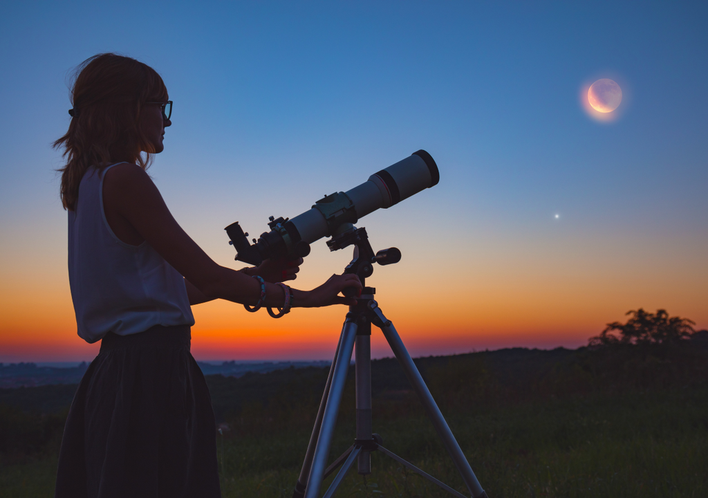 Mujer mirando por el telescopio Mujer mirando por el telescopio