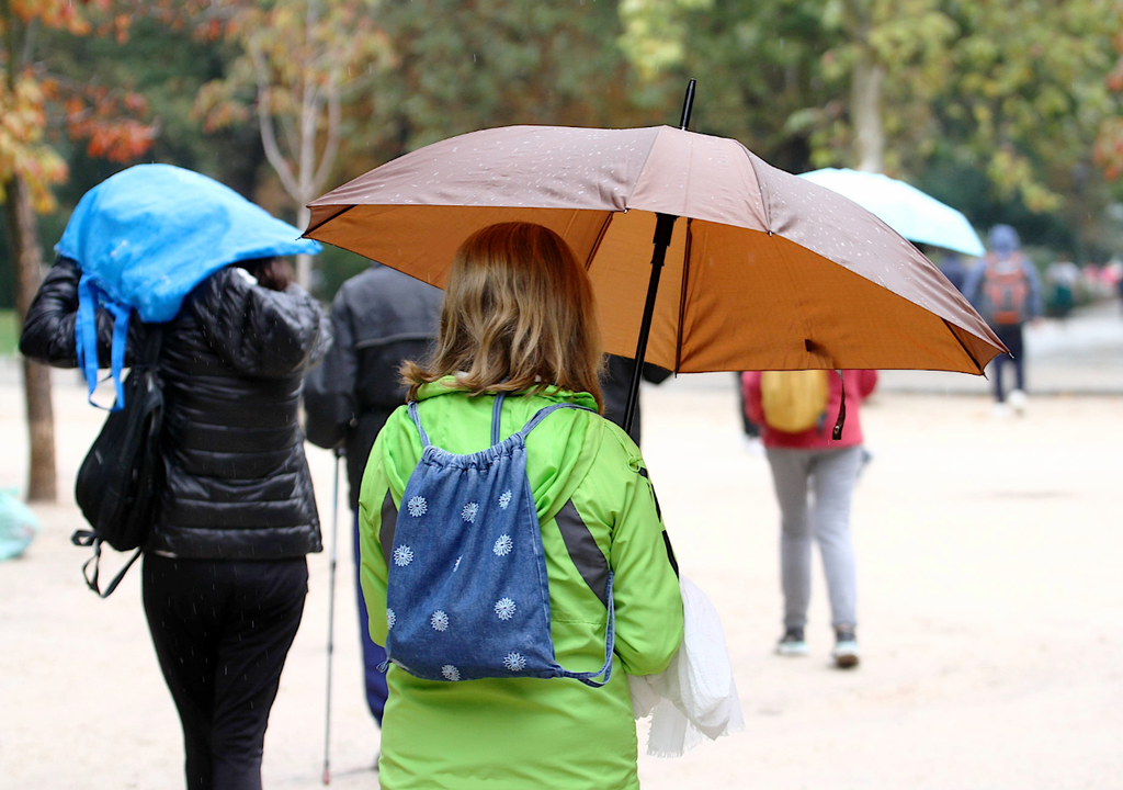personas con paraguas y ropa de frío personas con paraguas y ropa de frío