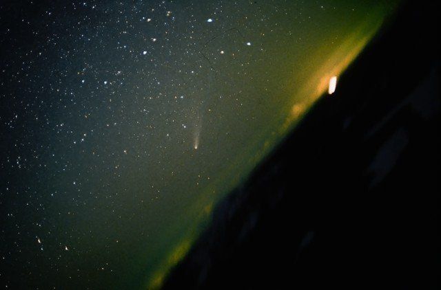 Figura 4. El cometa Halley durante su última visita, el 20 de marzo de 1986. El cometa aparece en el centro de la imagen, captada desde el pico de Javalambre (Teruel). A su derecha se aprecia, como un resplandor verde de fondo, la contaminación lumínica de la ciudad de Valencia, situada a más de 100 kilómetros en línea recta del lugar de la toma. (Foto de Vicente Aupí)