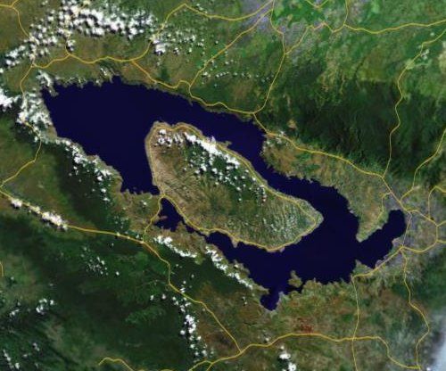Figura 4.- Imagen de satélite del gigantesco cráter del volcán Toba, en la isla de Sumatra, parcialmente sumergido bajo el agua. La isla que emerge en su parte central (Isla Samosir) tiene una longitud aproximada de 35 kilómetros en su diámetro mayor. FUENTE: NASA
