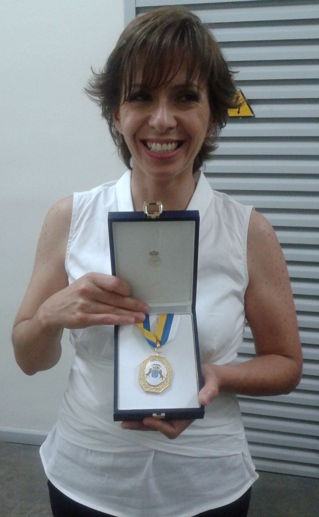 Victoria Palma posando sonriente con la Medalla de Oro del Gobierno de Canarias que le fue concedida en 2014