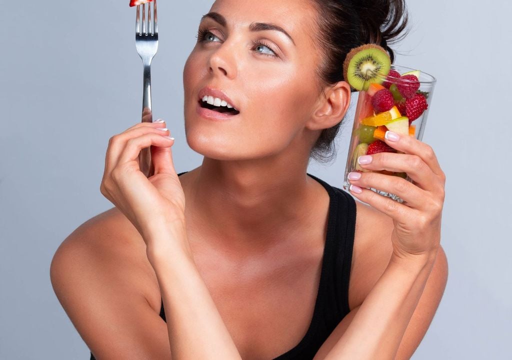 Mujer comiendo fruta Mujer comiendo fruta