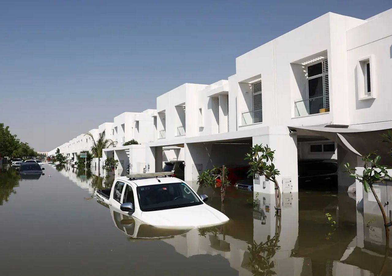 Coches parcialmente sumergidos en el agua, frente a un complejo residencial totalmente inundado tras las fuertes lluvias en Dubái, Emiratos Árabes Unidos.