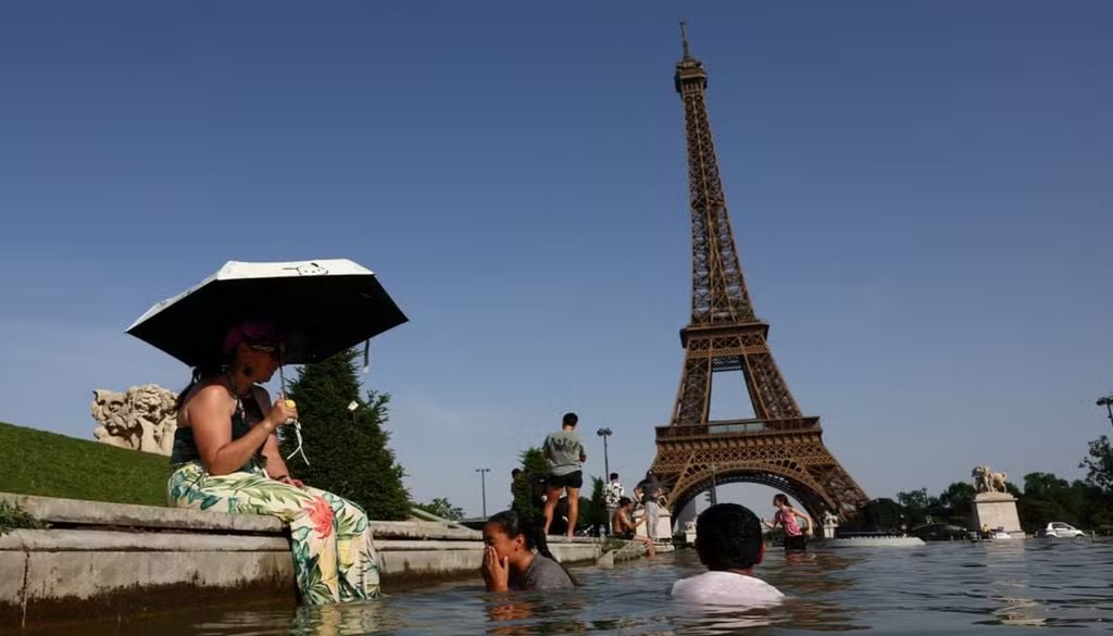 Pessoas se refrescando na fonte do Trocadéro, em frente a Torre Eiffel, durante onda de calor em Paris, na França. — Foto: Abdul Saboor/Reuters Pessoas se refrescando na fonte do Trocadéro, em frente a Torre Eiffel, durante onda de calor em Paris, na França. — Foto: Abdul Saboor/Reuters