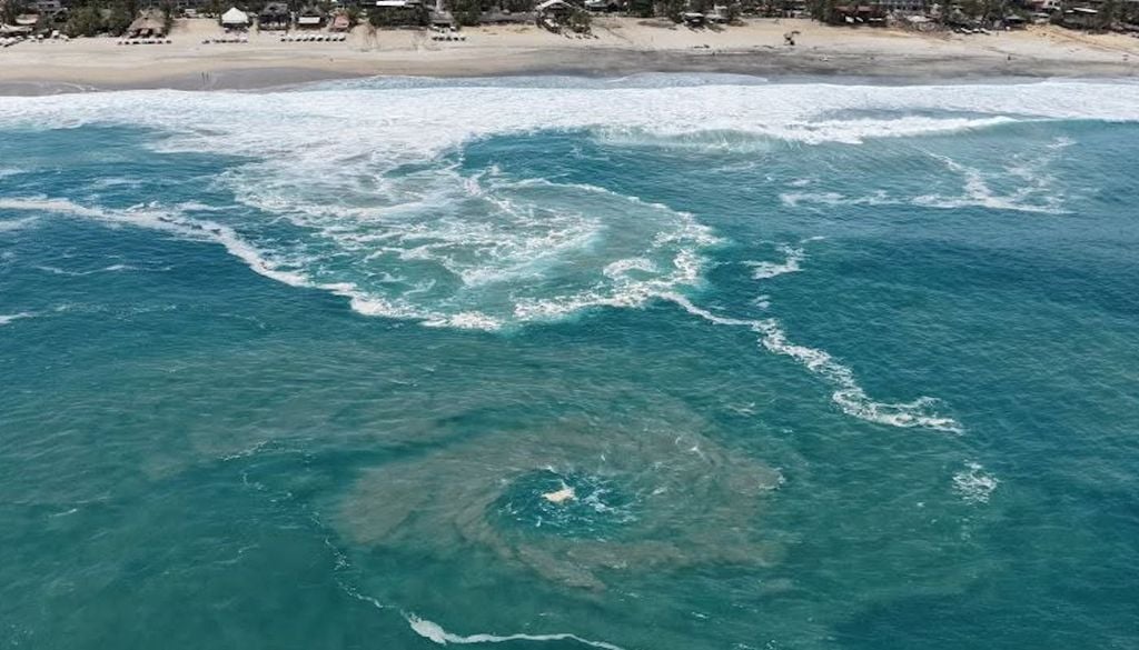 Estos remolinos aquí se forman mucho en zonas donde el fondo cambia de profundidad de golpe, como cerca de la Barra o en la zona de Zicatela, porque el agua corre muy rápido de regreso al océano. Son parte de la fuerza del mar en esta costa y se tienen que respetar porque arrastran hacia mar adentro. Fuente y fotografía: Jose Viruel Valladolid / Viruel Aéreo.