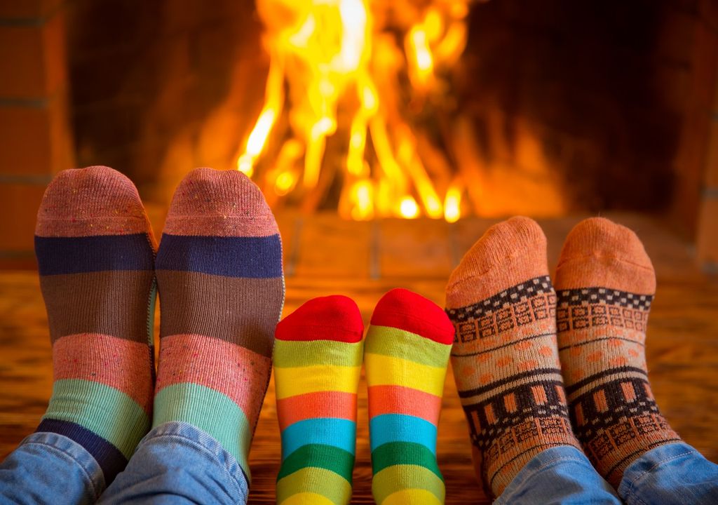 familia calentándose los pies frente a la chimenea