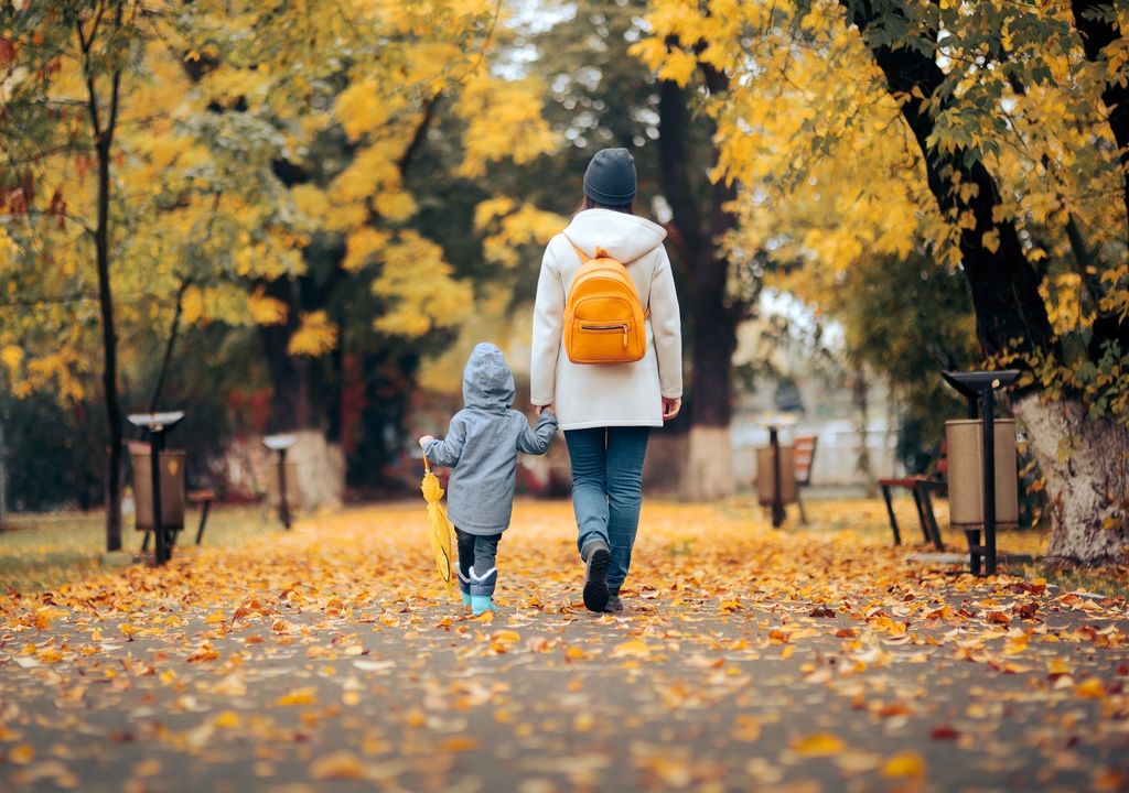 Madre e hijo paseando en día otoñal