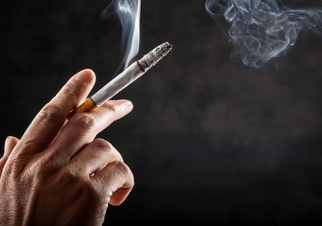 Persona fumando un cigarrillo Persona fumando un cigarrillo