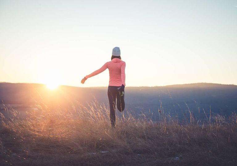 Mulher a exercitar-se com pôr do sol Mulher a exercitar-se com pôr do sol