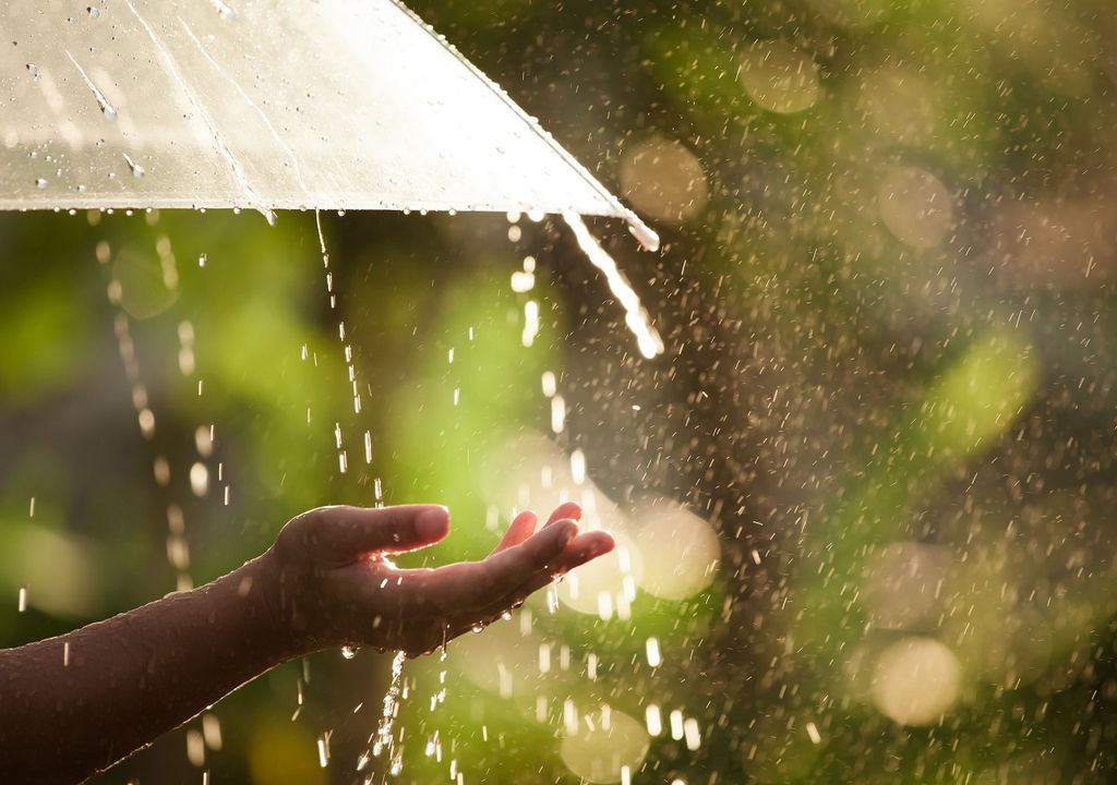 persona con brazo expendido tratando de sentir la lluvia