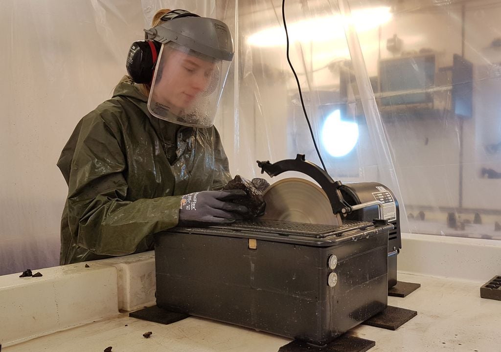 Vulkanisches Gestein als Archiv der Erdgeschichte: An Bord der METEOR durchtrennt eine Wissenschaftlerin eine Gesteinsprobe, die vom King’s Trough geborgen wurde. Bild: Fabian Hampel/ GEOMAR