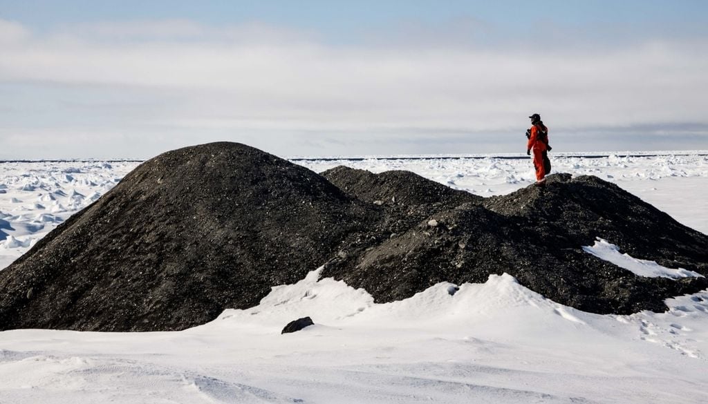 Forschende untersuchen einen Eisberg mit Gesteinsablagerungen auf der Oberfläche in der Framstraße. Bild: AWI/Mario Hoppmann