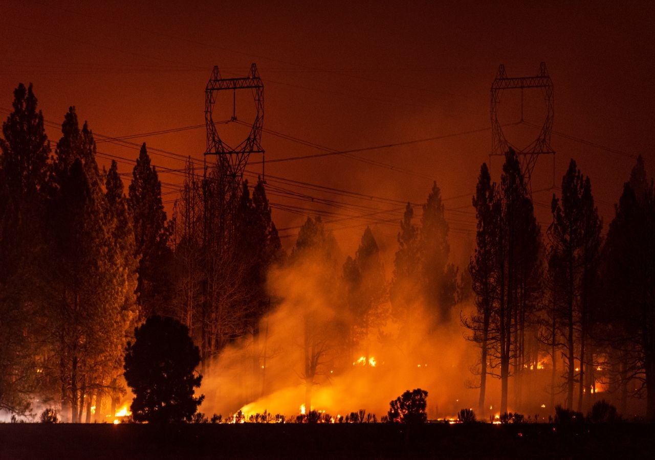 Incêndio florestal a lavrar com grande intensidade, com os consequentes danos na infraestrutura de abastecimento de energia elétrica.
