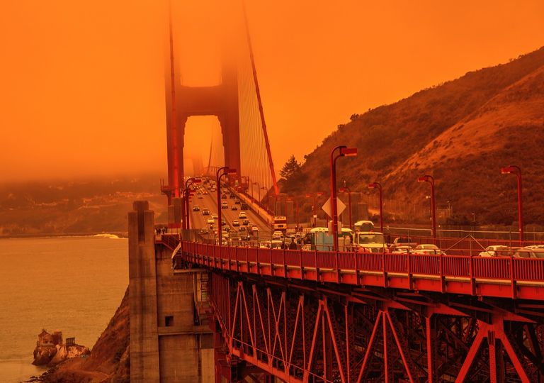 Tráfico sobre puente con cielo cubierto de humo incendio forestal Tráfico sobre puente con cielo cubierto de humo incendio forestal