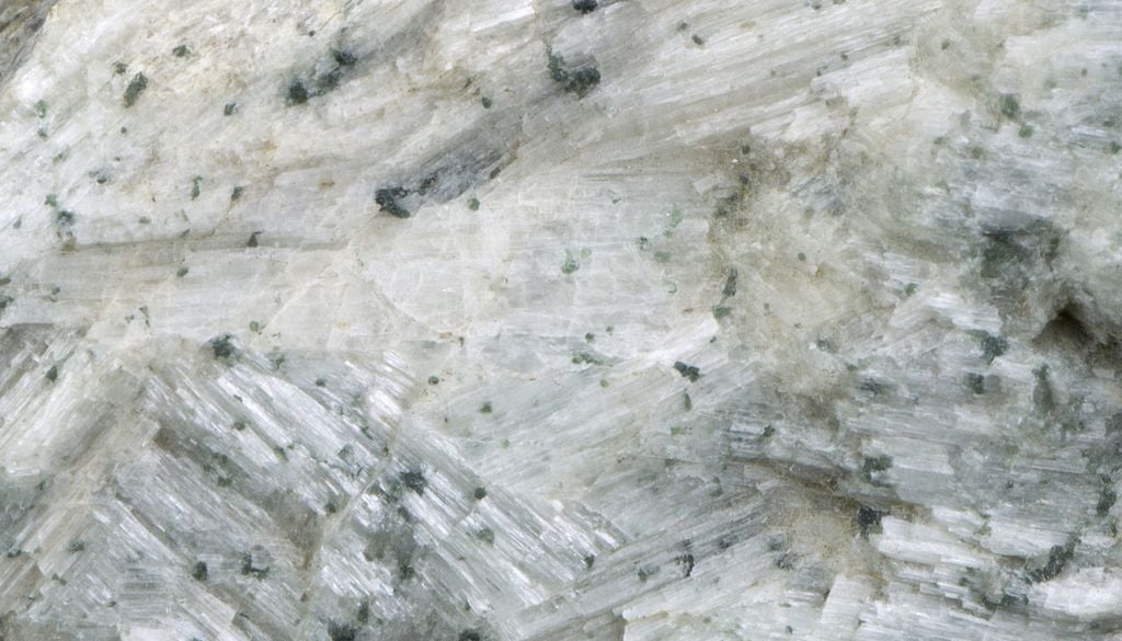 Das häufig in der Natur vorkommende Wollastonit besteht aus weißen und transparenten nadel-, lamellen- und stabförmigen Körnern. Bild: Estonian Museum of Natural History/202332/CC BY-SA 4.0