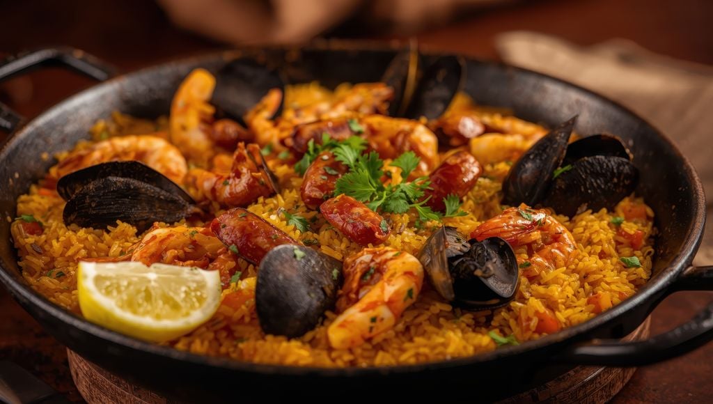 Appetitlich: An der Küste gibt's die Paella mit Meeresfrüchten. Foto: Adobe Stock