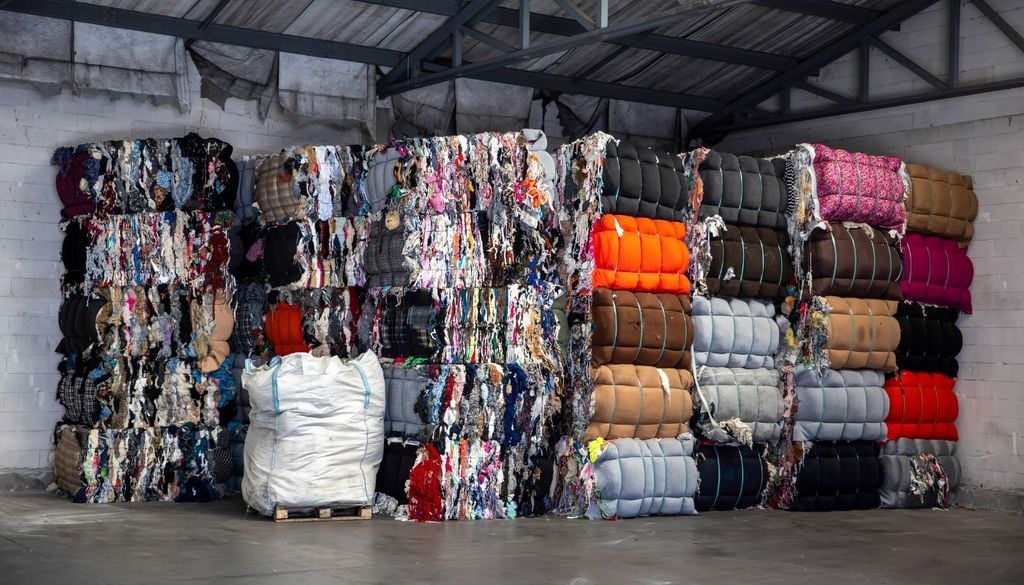 inquinamento fast fashion Balle di rifiuti tessili in attesa di essere smaltiti