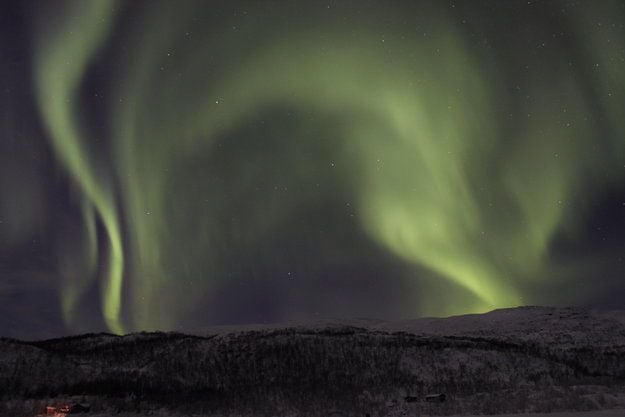 Una hermosa aurora boreal ilumina el cielo sobre el paisaje nevado de Tromsø, Noruega.
