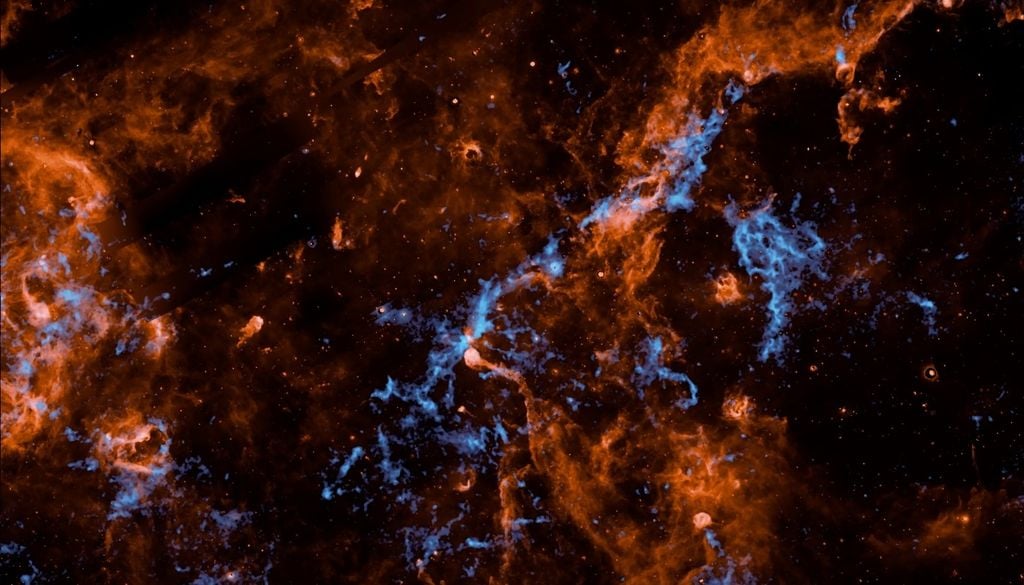 SPHEREx de la NASA detectó hielo de agua (azul) e hidrocarburos aromáticos en Cygnus X. Crédito: NASA/JPL-Caltech/IPAC/Hora et al.