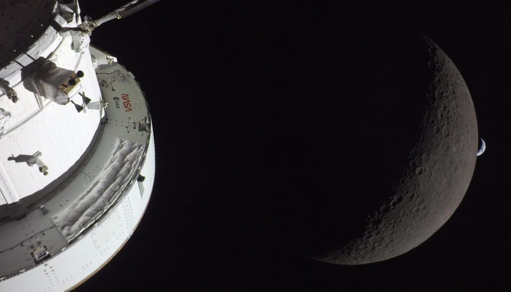 Questa foto è stata scattata da una fotocamera installata su un pannello solare della Orion. Ritrae parte della capsula, la Luna e una piccola falce della Terra nello spazio nero che avvolge tutto.