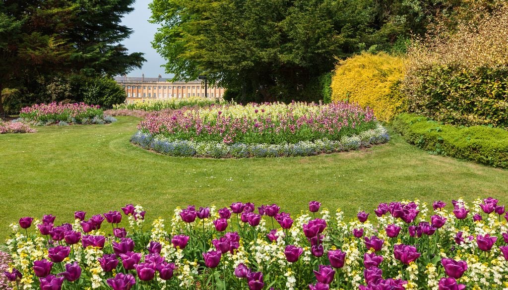 Des parterres de fleurs au Royal Victoria Park, avec le célèbre Royal Crescent visible au loin, en arrière-plan. Des parterres de fleurs au Royal Victoria Park, avec le célèbre Royal Crescent visible au loin, en arrière-plan.