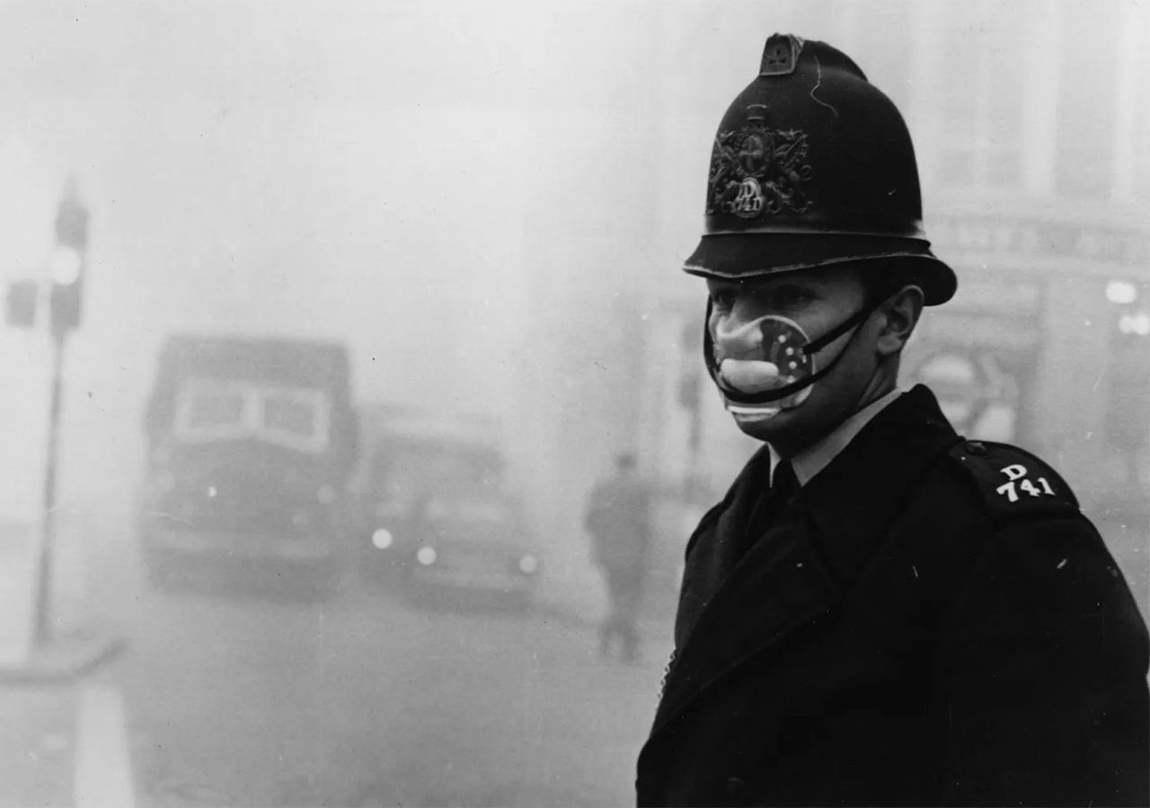 Un bobby con máscara y su típico casco, dirigiendo el tránsito en el Gran Smog de 1952