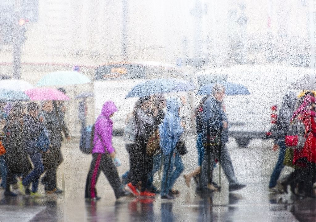 Personas cruzando la calle en día de lluvia